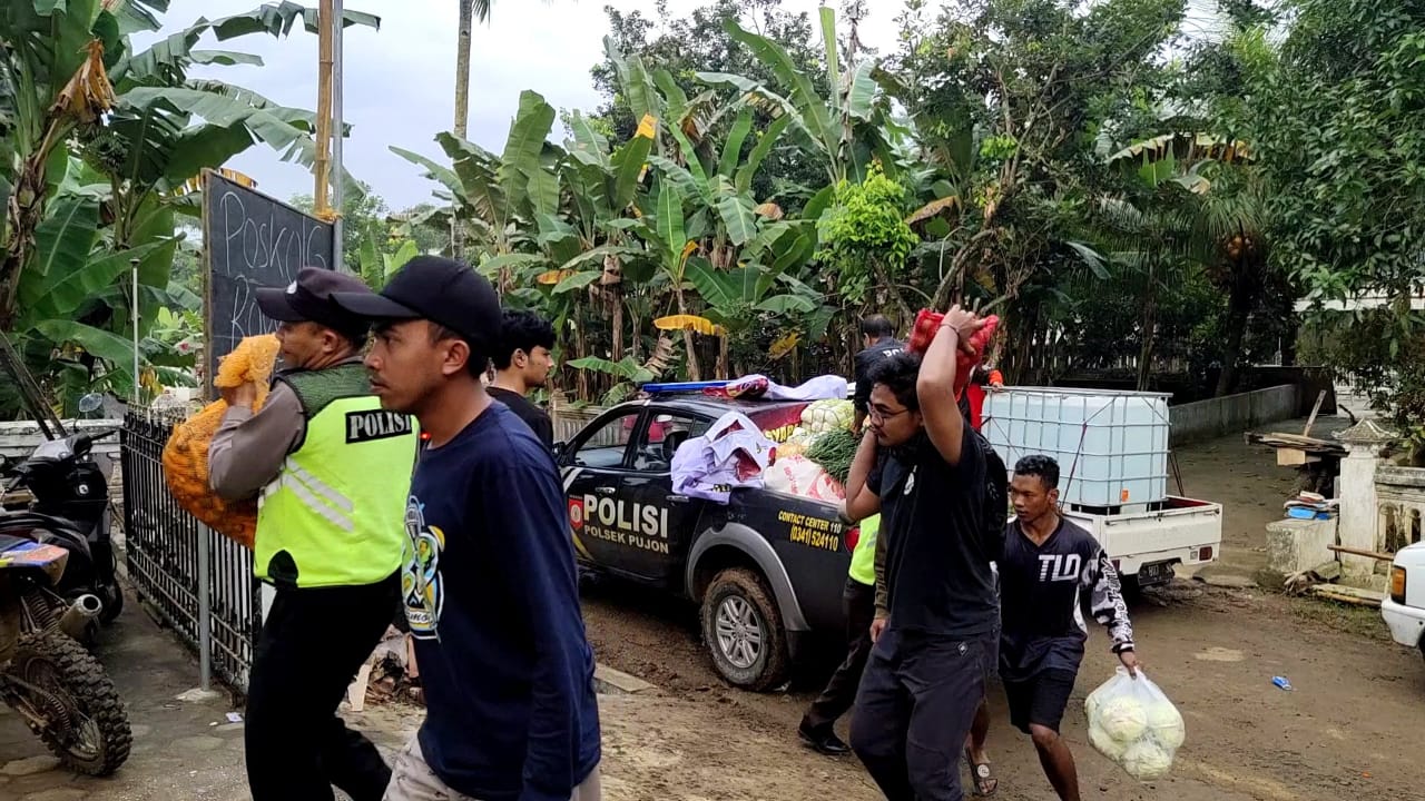 Personil Polresta Malang Kota, saat mendistribusikan bantuan langsung ke daerah terdampak bencana alam di Malang Selatan.Jawa Timur.